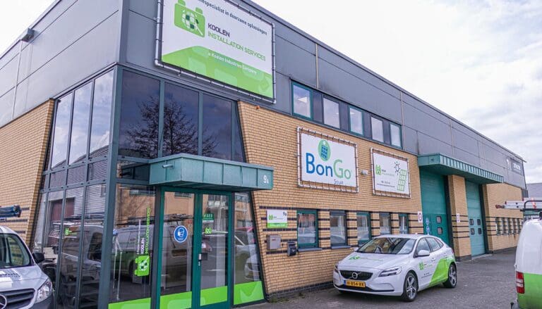 Bedrijfspand met grote groene gevelreclame, raamfolie op de ramen en opvallende reclamefolie voor branding.