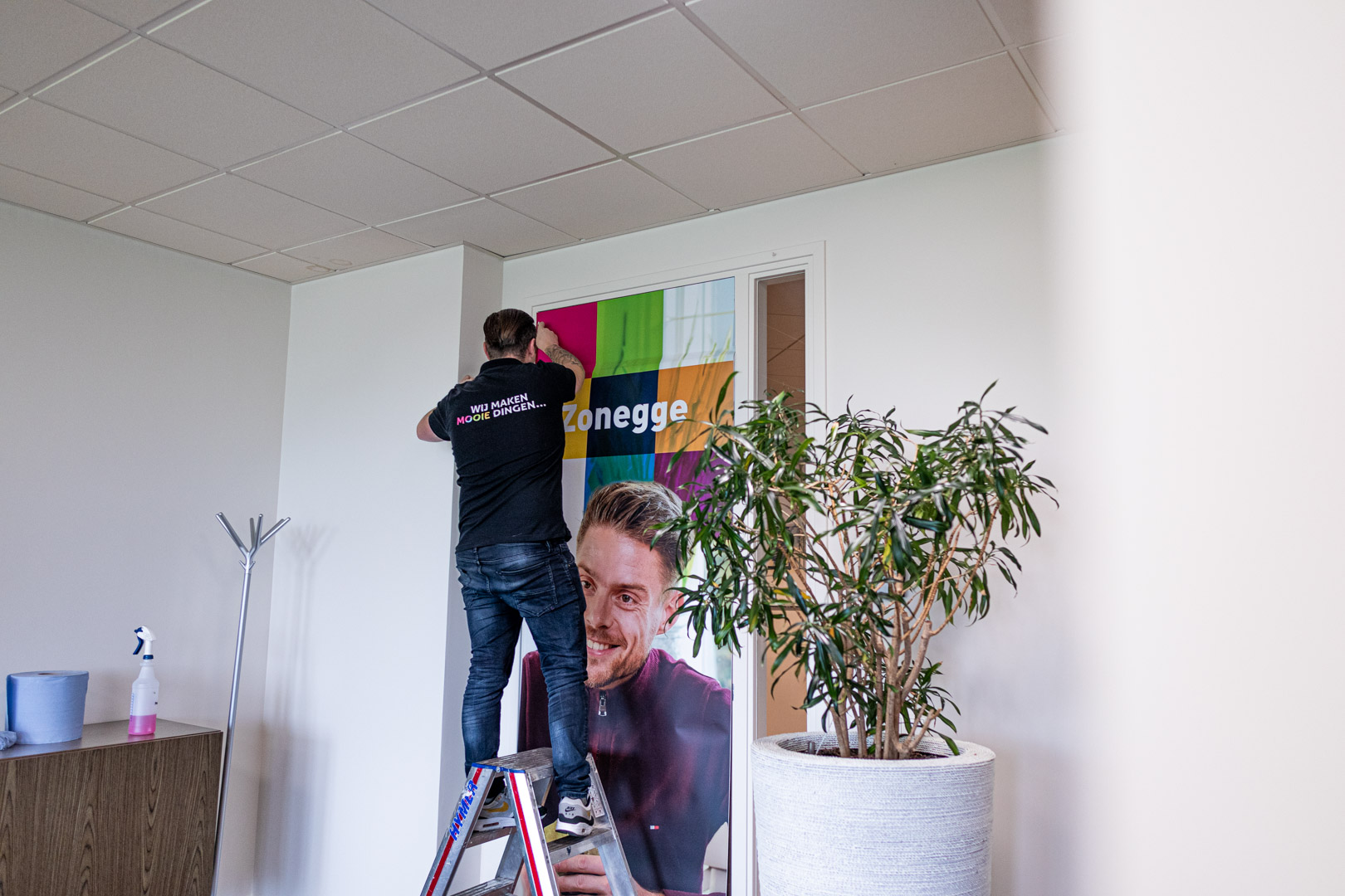 Monteur plakt een grootformaat print op een deur