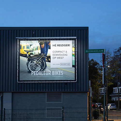 pandoek frame op een donkere gevel, met een fietsadvertentie.